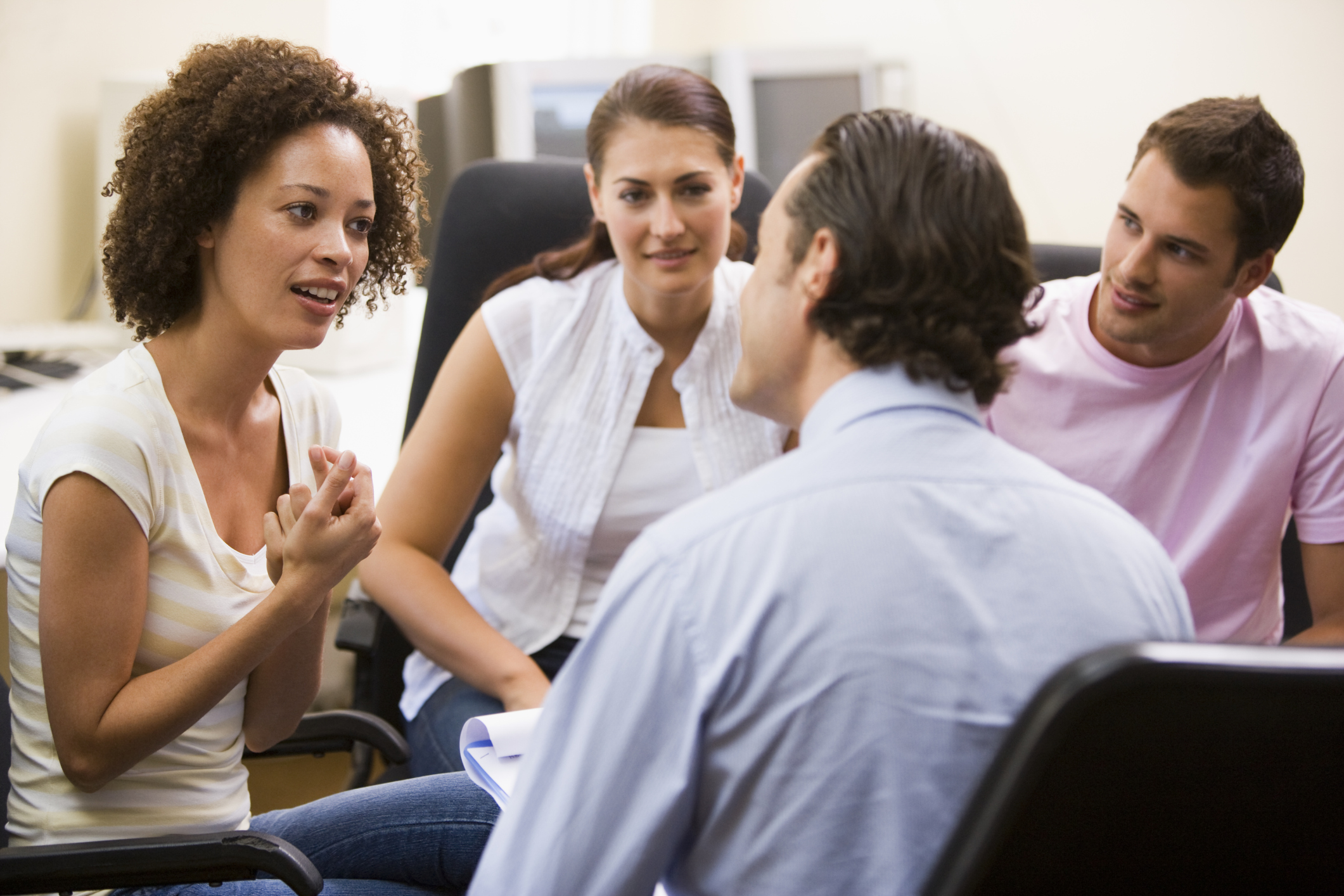 Man giving lecture to three people