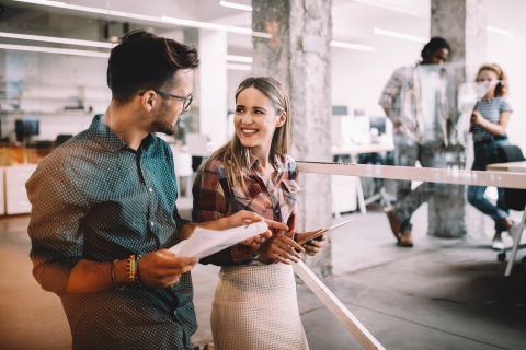 Two employees walking and talking in an office