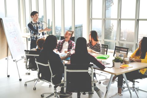 Colleagues sitting around a conference table talking